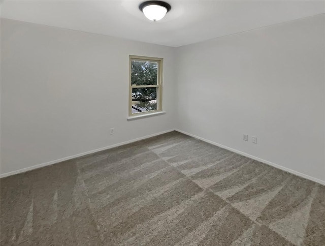 unfurnished room with carpet and baseboards