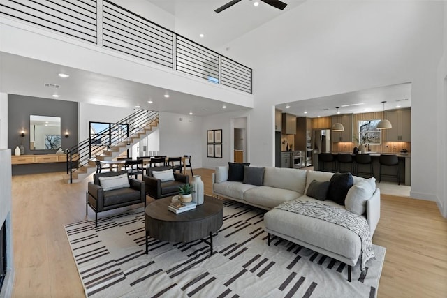 living area featuring light wood-type flooring, visible vents, stairway, and recessed lighting