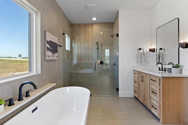 bathroom featuring a freestanding bath, a shower stall, vanity, and tile patterned floors