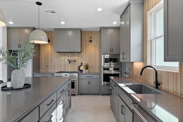 kitchen featuring appliances with stainless steel finishes, gray cabinets, visible vents, and a sink