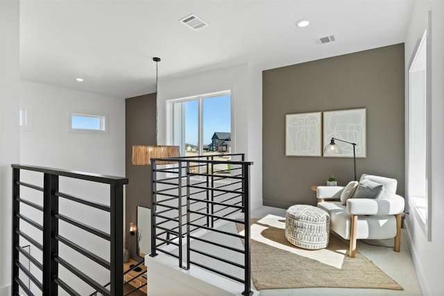 interior space with visible vents, a wealth of natural light, and an upstairs landing