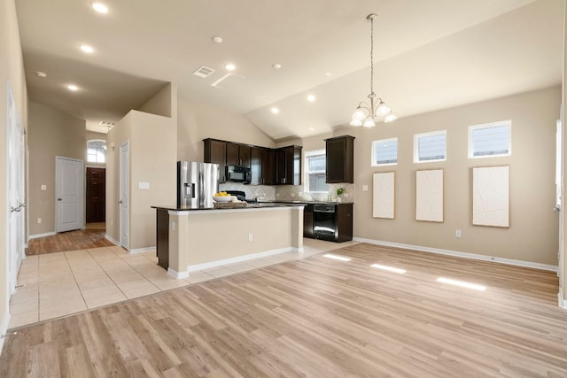 kitchen featuring visible vents, light wood-style floors, dark brown cabinets, a center island, and black appliances