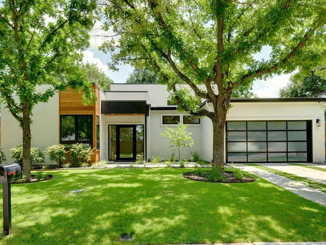 view of front of house with concrete driveway, a front yard, an attached garage, and stucco siding