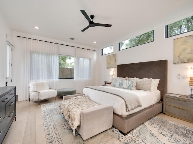 bedroom featuring a ceiling fan, multiple windows, visible vents, and light wood-style floors