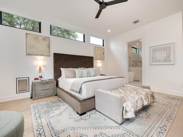 bedroom featuring light wood finished floors, visible vents, baseboards, ensuite bath, and recessed lighting