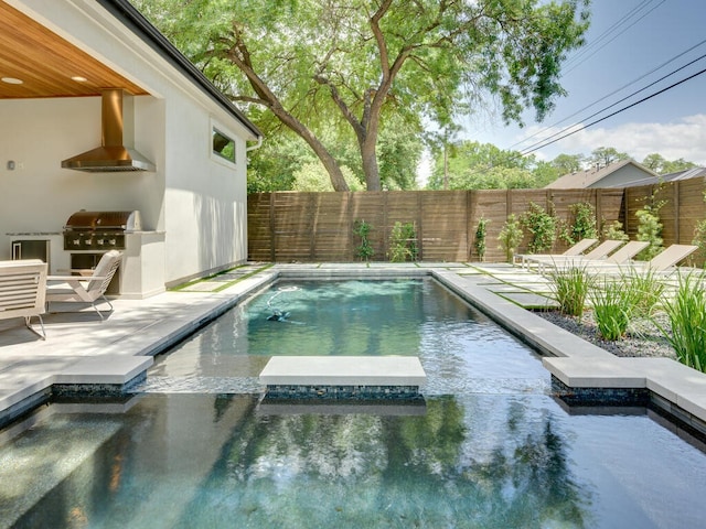 view of swimming pool featuring area for grilling, a fenced backyard, a pool with connected hot tub, and a grill