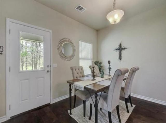 dining space featuring dark wood finished floors, visible vents, and baseboards