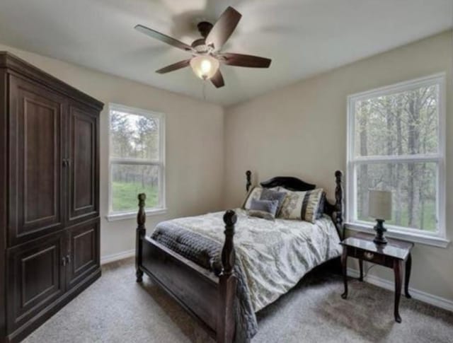 carpeted bedroom with ceiling fan and baseboards