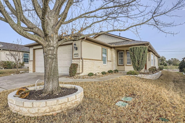 view of front facade with a garage, concrete driveway, stone siding, and stucco siding