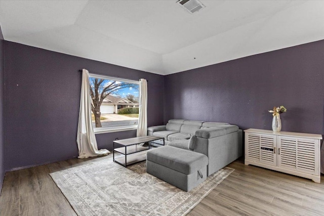 interior space featuring vaulted ceiling, wood finished floors, and visible vents