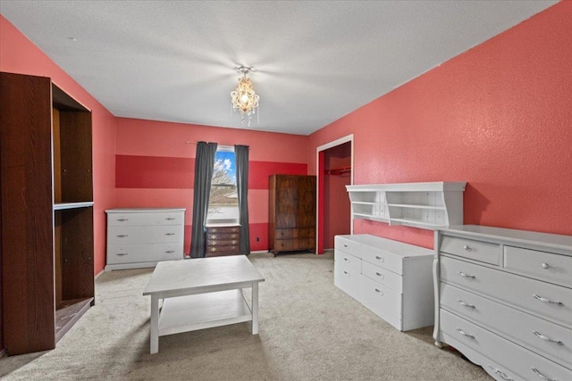 bedroom featuring light carpet, an inviting chandelier, and a textured wall