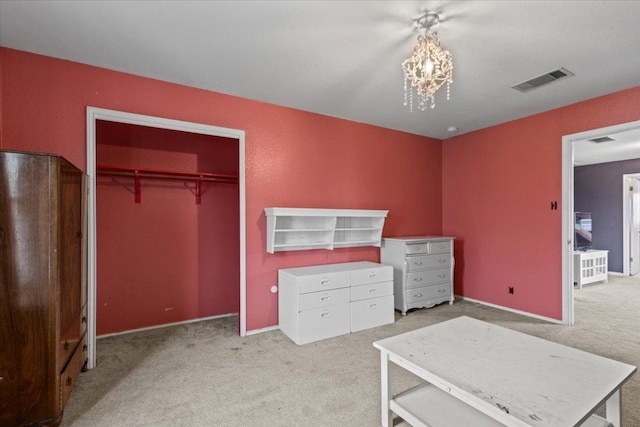 unfurnished bedroom with a closet, visible vents, carpet flooring, and an inviting chandelier