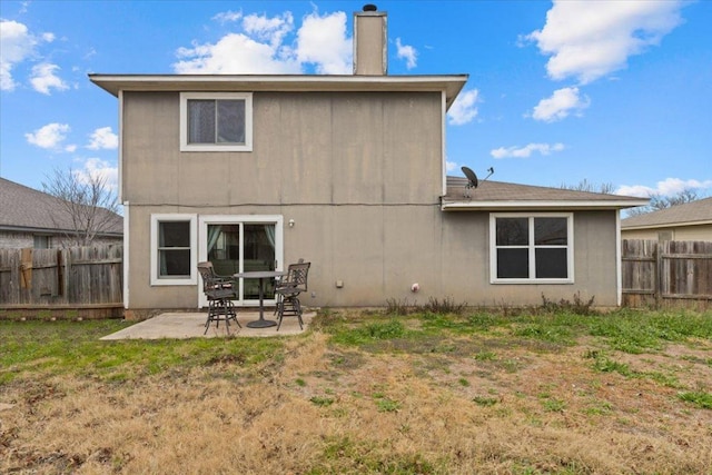 back of house featuring fence, a chimney, and a patio