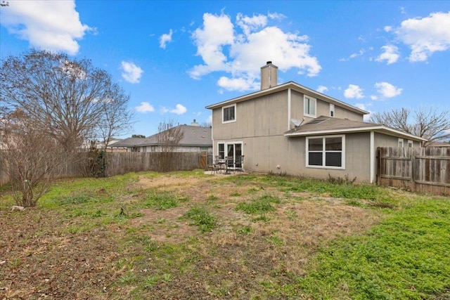 rear view of property with a patio area, a fenced backyard, and a chimney