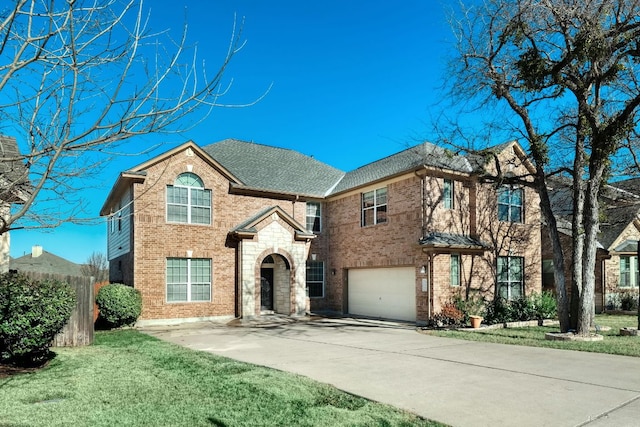 view of front of home with concrete driveway, brick siding, an attached garage, and a front yard