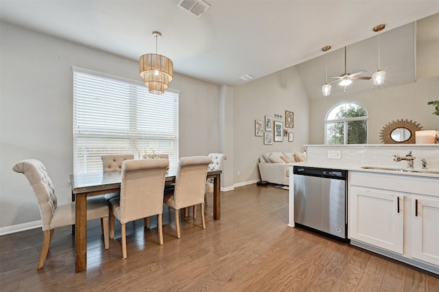 kitchen featuring wood finished floors, a sink, visible vents, open floor plan, and stainless steel dishwasher