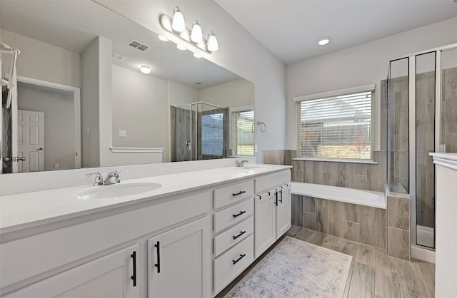 full bathroom featuring a garden tub, a sink, visible vents, double vanity, and a stall shower