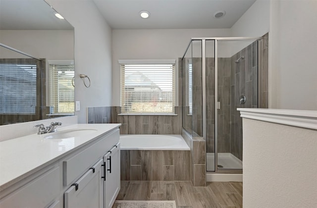 bathroom featuring a stall shower, plenty of natural light, vanity, and a bath