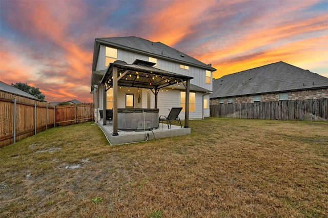 back of house with a patio, a hot tub, a gazebo, and a lawn