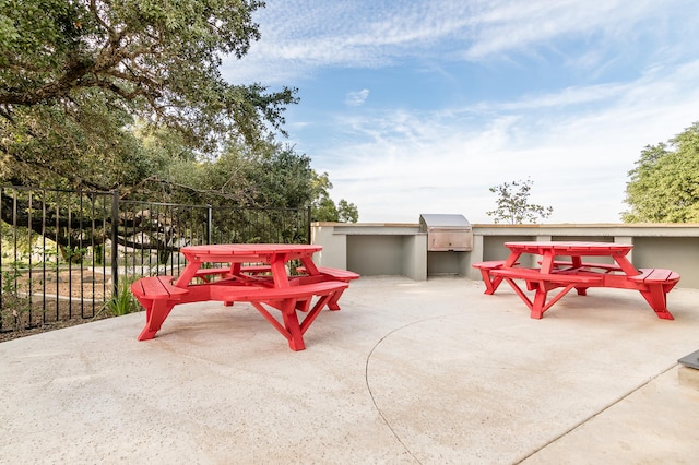 exterior space with fence, an outdoor kitchen, and a patio