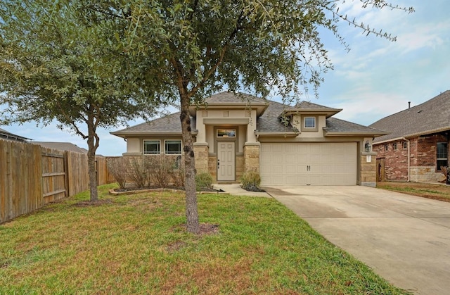 view of front of property with driveway, an attached garage, fence, a front lawn, and stucco siding