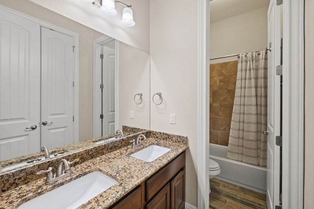 bathroom featuring wood finished floors, a sink, and shower / tub combo with curtain