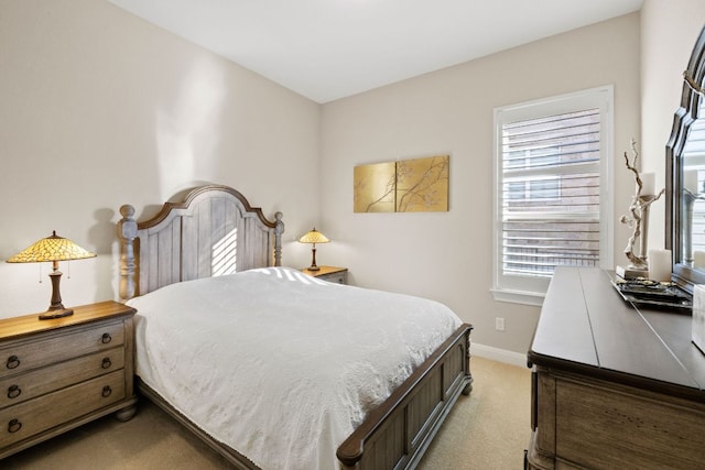 bedroom with baseboards and light colored carpet