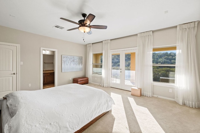 bedroom featuring access to exterior, french doors, visible vents, ensuite bathroom, and light carpet