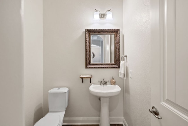 bathroom with toilet and baseboards