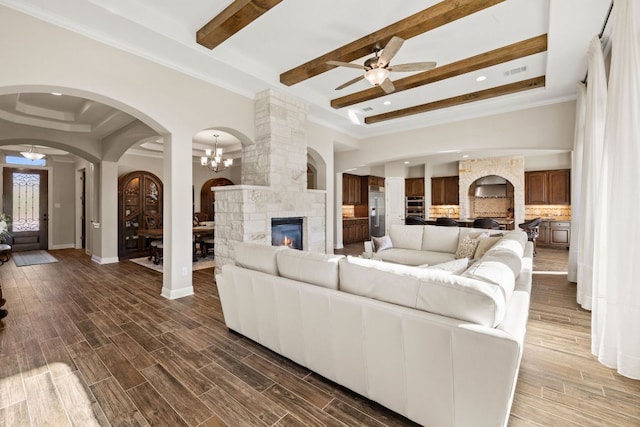 living area with baseboards, a raised ceiling, and wood finish floors