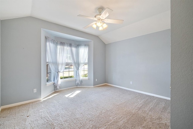 unfurnished room featuring vaulted ceiling, carpet flooring, and baseboards