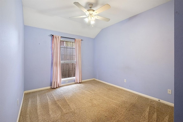 spare room featuring baseboards, carpet, ceiling fan, and vaulted ceiling