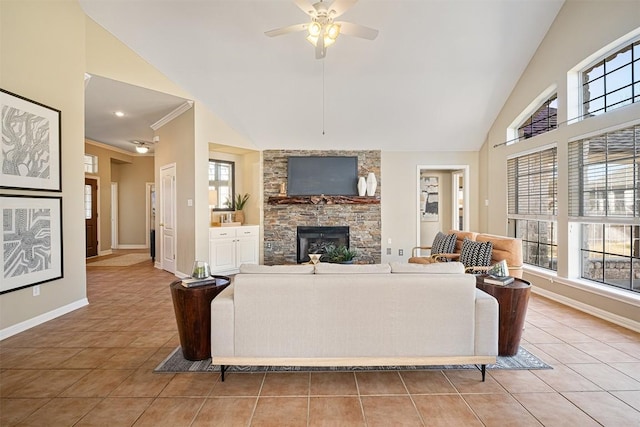 living area featuring baseboards, light tile patterned floors, a stone fireplace, high vaulted ceiling, and a ceiling fan