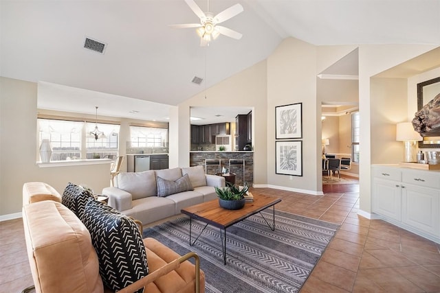 living area with visible vents, baseboards, light tile patterned floors, high vaulted ceiling, and a ceiling fan