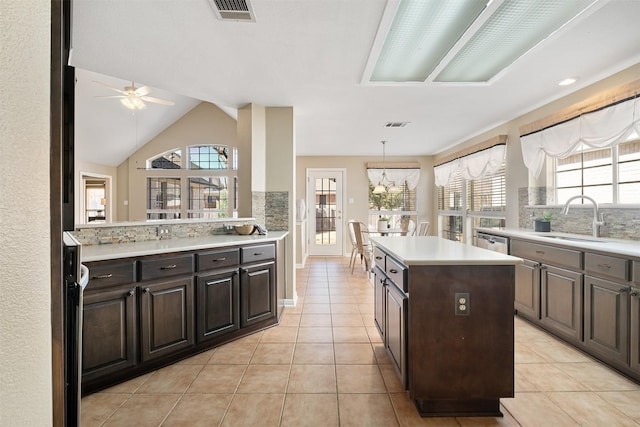 kitchen with a sink, visible vents, a center island, and light countertops