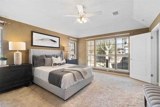 carpeted bedroom with visible vents, ceiling fan, and vaulted ceiling