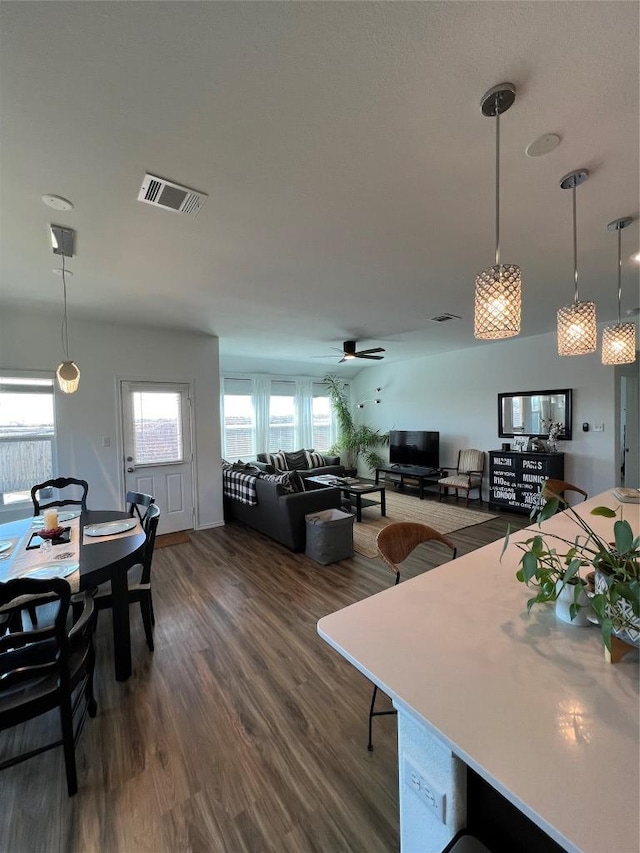 dining area with dark wood-type flooring, visible vents, and ceiling fan