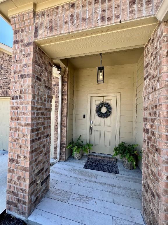 property entrance featuring brick siding