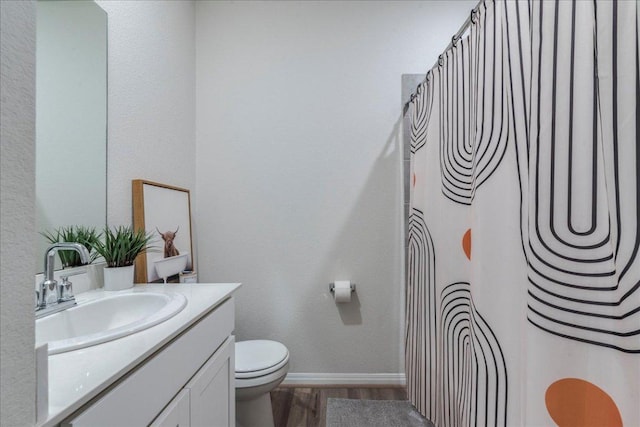 full bathroom featuring baseboards, toilet, a shower with curtain, wood finished floors, and vanity