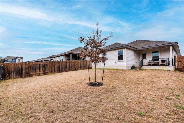 rear view of house with a yard, a patio area, and a fenced backyard