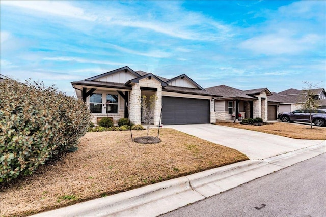 view of front of property with concrete driveway, an attached garage, board and batten siding, stone siding, and a front lawn