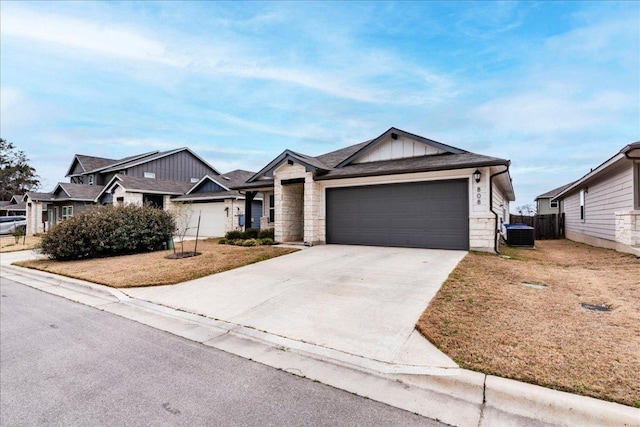 view of front of home featuring concrete driveway, board and batten siding, central AC, fence, and a garage