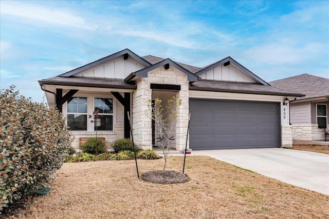 view of front facade with an attached garage, stone siding, board and batten siding, and concrete driveway