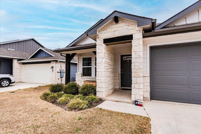 view of front of property featuring a garage, stone siding, and board and batten siding