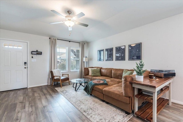 living room featuring a ceiling fan, lofted ceiling, baseboards, and wood finished floors