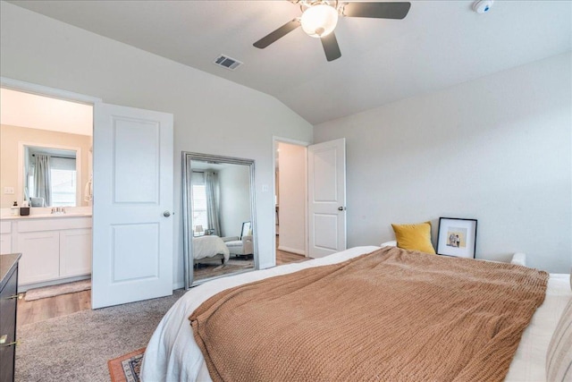 bedroom featuring a ceiling fan, lofted ceiling, visible vents, and connected bathroom