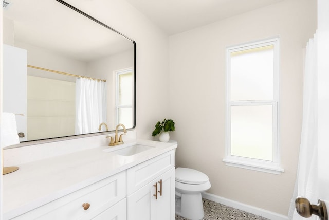 bathroom with toilet, baseboards, and vanity