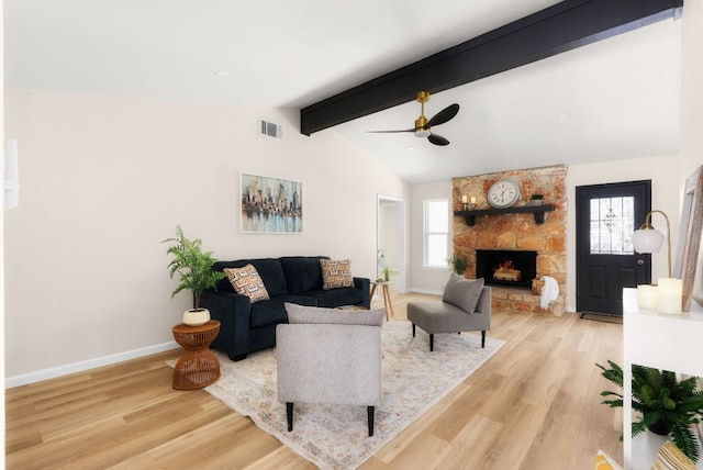 living room with lofted ceiling with beams, plenty of natural light, wood finished floors, and visible vents