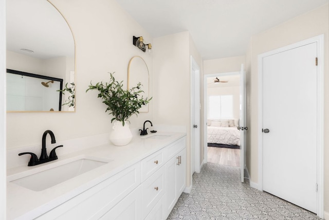 full bath featuring double vanity, connected bathroom, and a sink