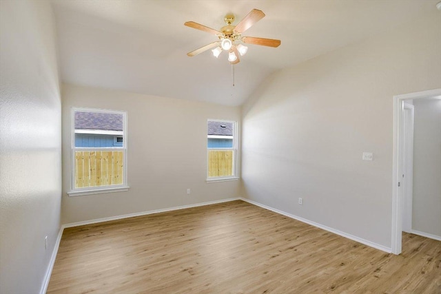 unfurnished room featuring lofted ceiling, ceiling fan, light wood-style flooring, and baseboards